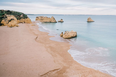 High angle view of rock formation at beach against sky