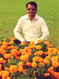 Full length of man with yellow flowers