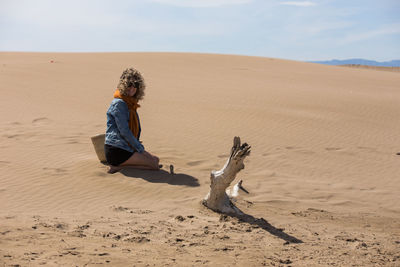 Full length of man on sand dune in desert against sky