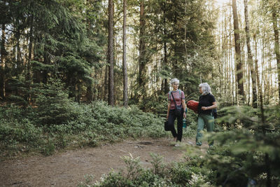 Two senior women hiking in forest