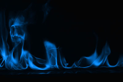 Close-up of blue smoke against black background