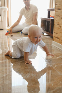 Family with kids on the floor having fun. father and baby son are happy in the morning in livingroom