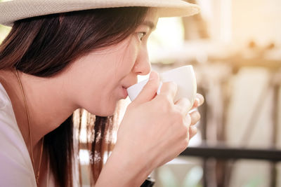 Close-up portrait of a beautiful young woman drinking water