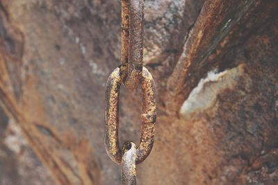 Close-up of rusty metal hanging against wall