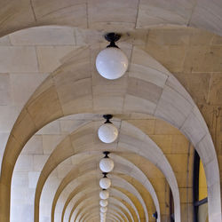 Low angle view of illuminated lamp hanging on ceiling in building