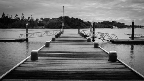 Boardwalk amidst trees against sky