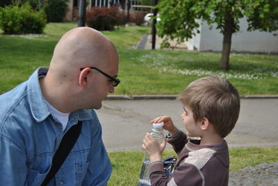 Father and son with water bottle in city