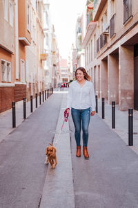 Woman with dog walking on street