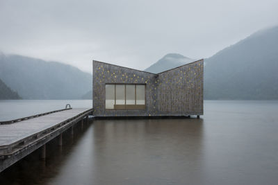 Scenic view of lake and sauna against sky