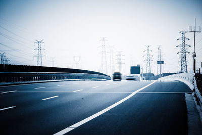 Cars on road against sky in city