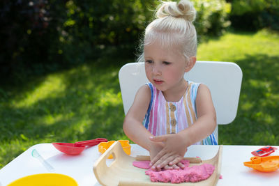 Full length of a girl sitting on table