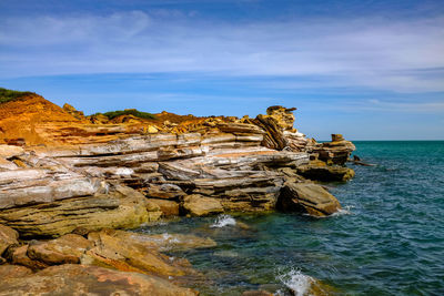 Rock formations in sea against sky