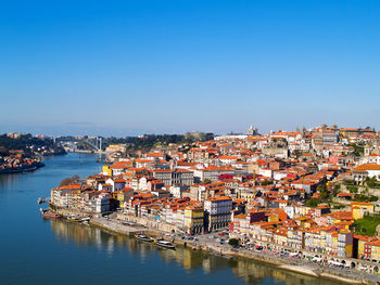 Townscape by sea against clear blue sky