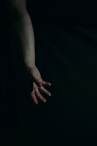 Close-up of hand over black background