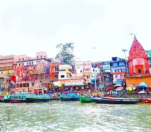 Boats in river with buildings in background