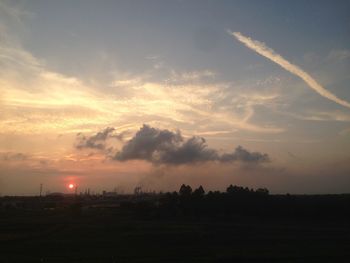 Scenic view of silhouette field against sky at sunset