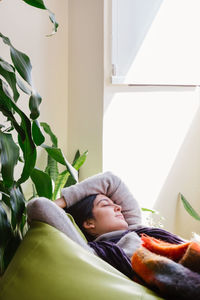 Woman relaxing on bean bag at home