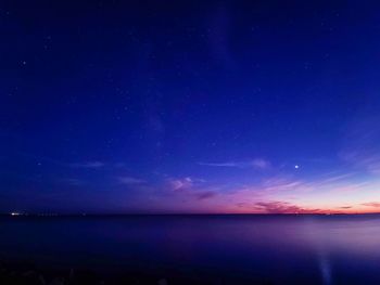 Scenic view of sea against blue sky at night