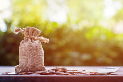 Close-up of jute bag and coins on table