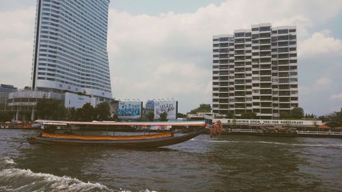 Boats in river with buildings in background