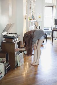 Young woman choosing a record album from a shelf
