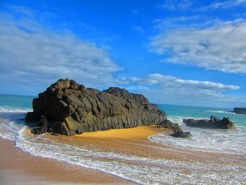 Scenic view of beach against blue sky