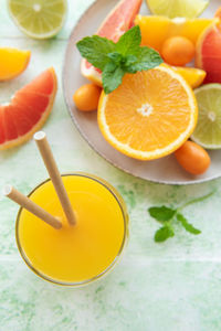 Glass of juice and fresh citrus fruits