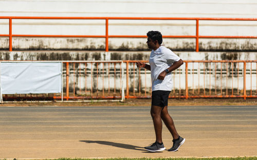 Full length of man running on track