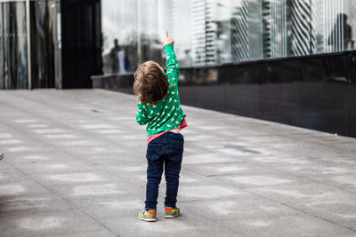 Rear view of boy standing in city