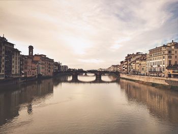 Ponte vecchio bridge over arno river amidst buildings