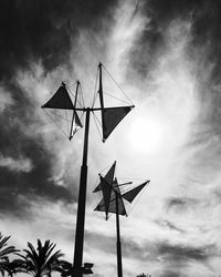 Low angle view of windmills against cloudy sky