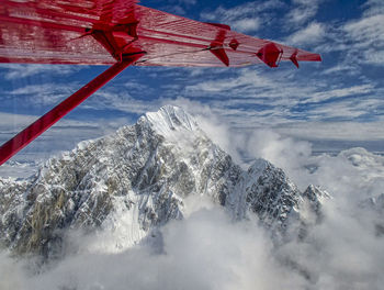 Scenic view of snowcapped mountains against airplane wing and sky