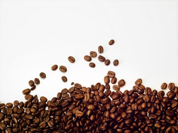 High angle view of coffee beans against white background