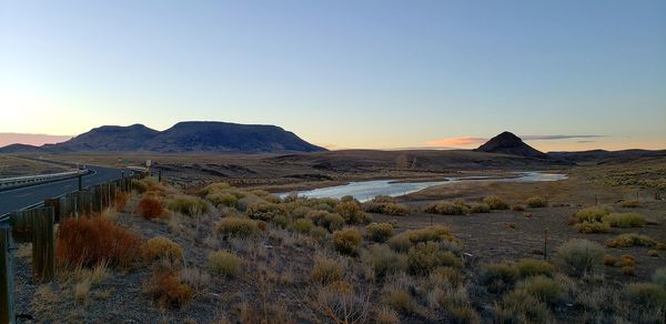 Scenic view of landscape against clear sky during sunset