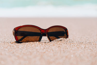 Close-up of sunglasses on sand