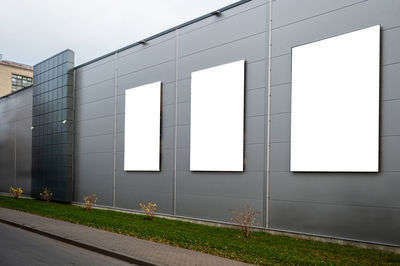 Three blank white billboard for advertisement on the facade of building, outdoor advertising mockup
