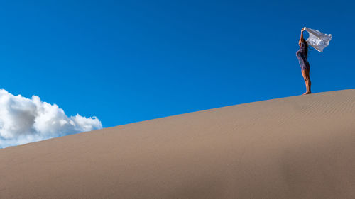 Low angle view of man against blue sky