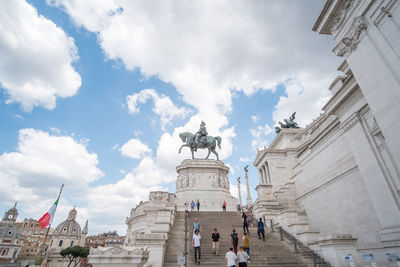 Statue in city against sky