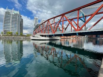 Bridge over river in city against sky