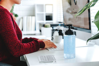 Midsection of woman holding drink at home