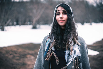 Portrait of young woman standing in snow