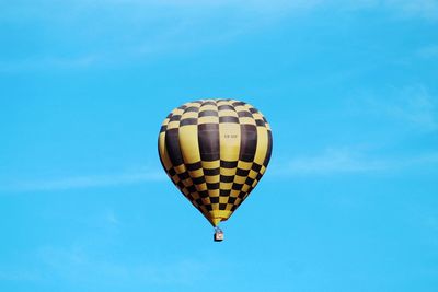 Low angle view of hot air balloon against clear blue sky