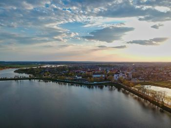 High angle view of river by buildings against sky during sunset