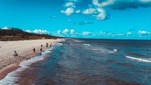 People on beach against blue sky