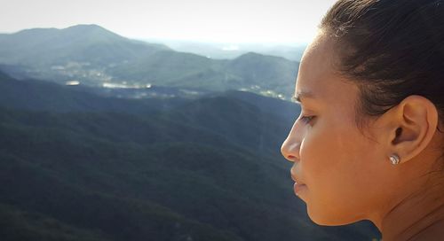 Side view of woman against mountains