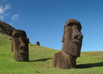 Moai statue on field against sky
