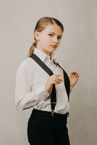 Portrait of young woman standing against white background