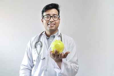 Portrait of young man standing against white background