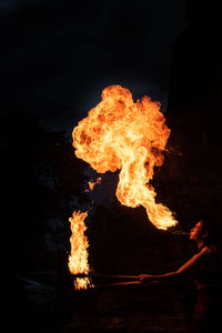 Woman performing breath fire at night