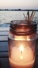 Close-up of burning candle on table